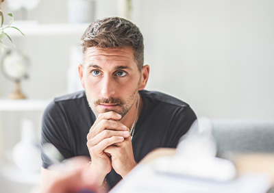 A focused adult man listening attentively during a therapy session.
