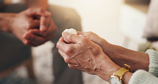 Hands of a hypnotherapist and client engaged in a therapeutic session.