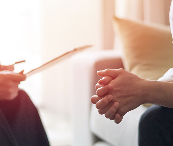 hands of a client resting on their lap during a therapy session with a hypnotherapist