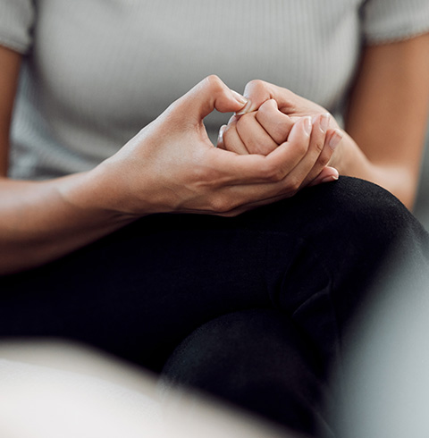 Hands clasped together, demonstrating a calm and focused state in a therapy setting.